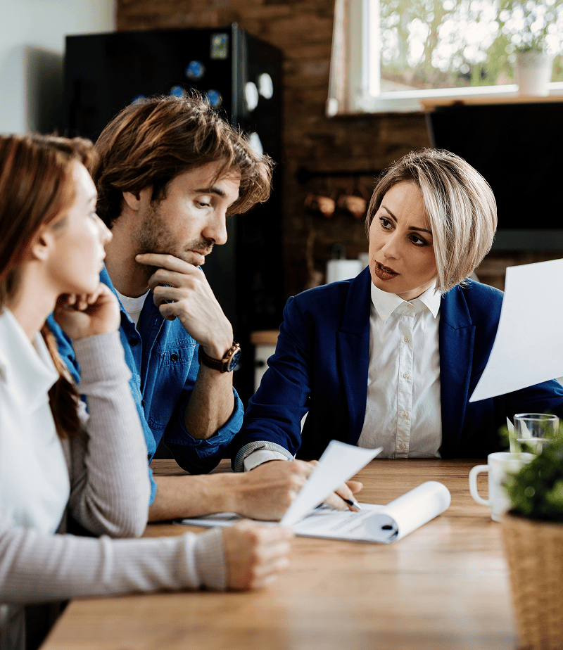 Female lawyer carefully explaining partition actions and property dispute documents to a focused couple